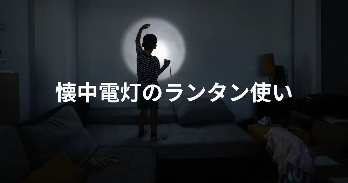 暗い部屋で懐中電灯を照らす子供